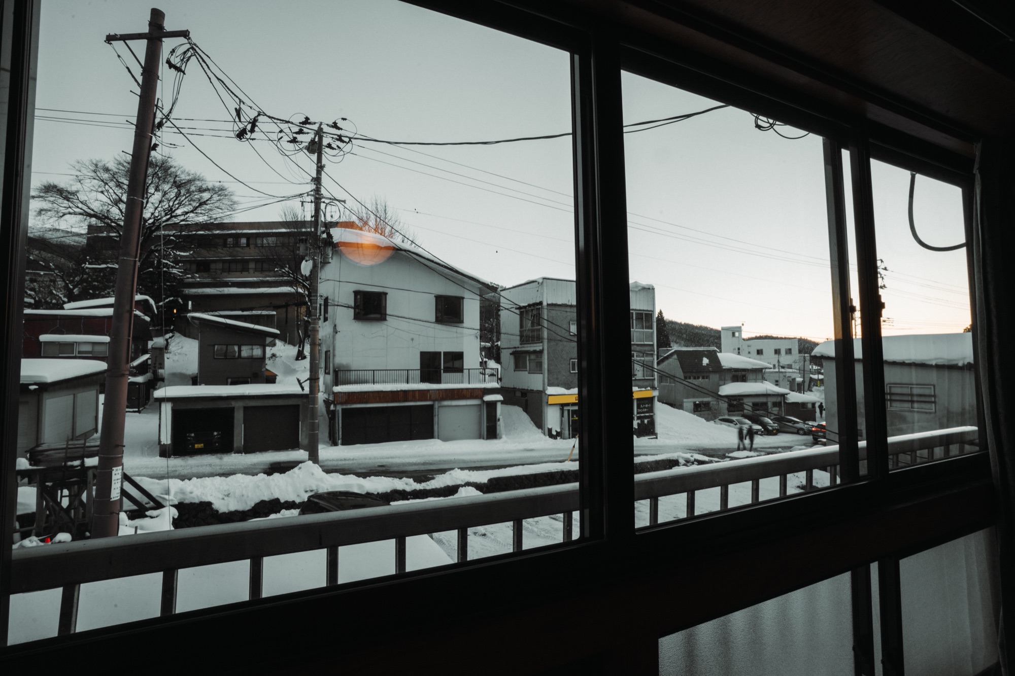 三浦屋の窓越しに見える、雪の積もる高湯通りの街並み